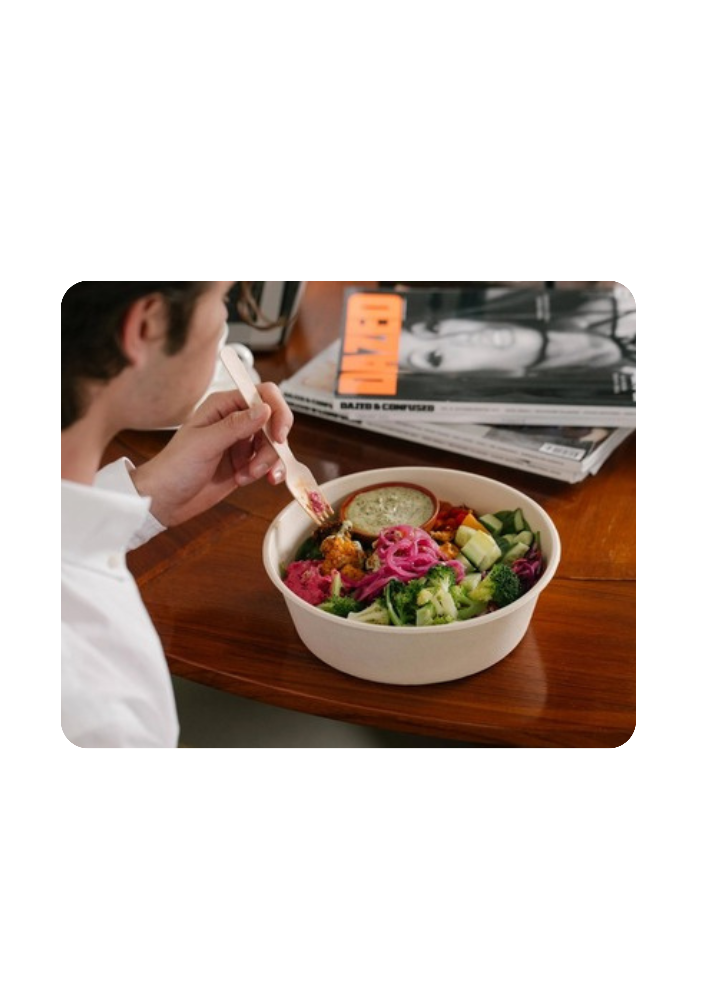 A person eating a bowl of salad from The Salad Project