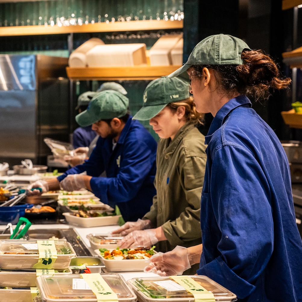 Staff behind the counter at Salad Project fulfil orders