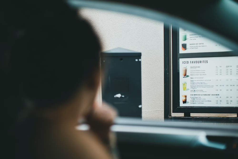 customer in a car talking to a drive-thru